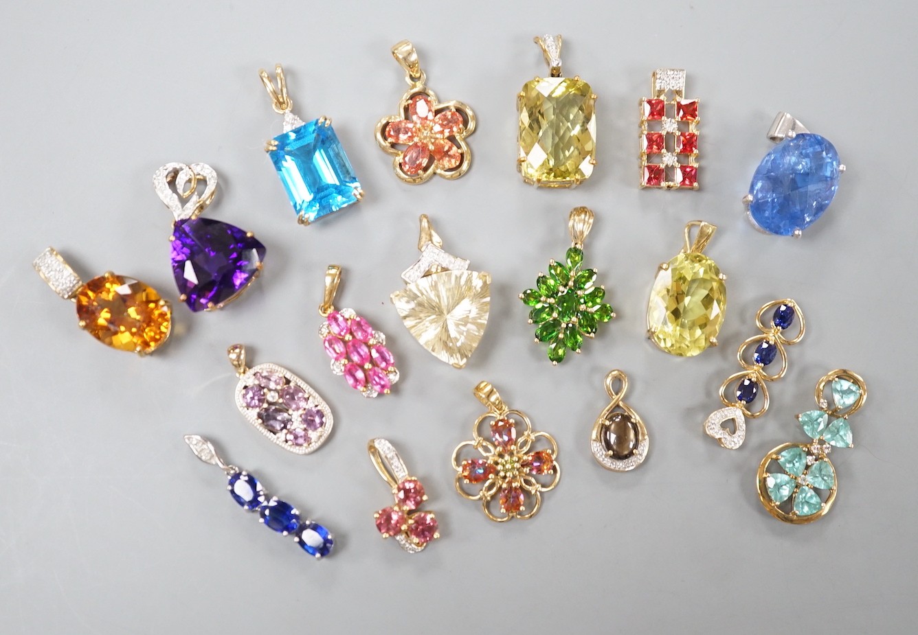 Nineteen assorted modern 9ct gold or yellow metal and gem set pendants, including citrine and amethyst and a 9ct gold chain, gross weight 63.6 grams.